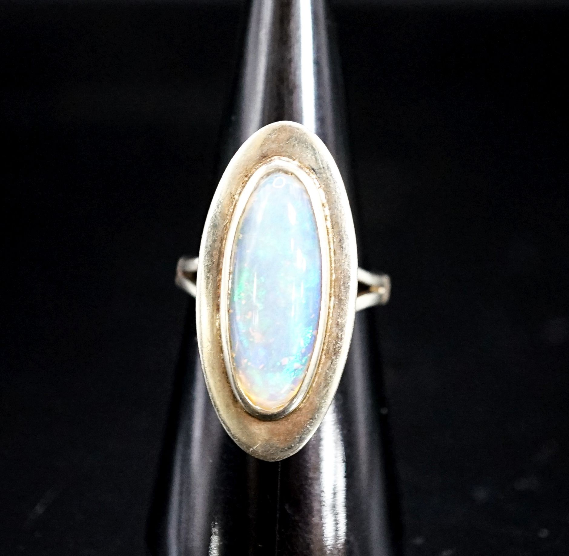 A 9ct white gold and oval cabochon white opal set dress ring